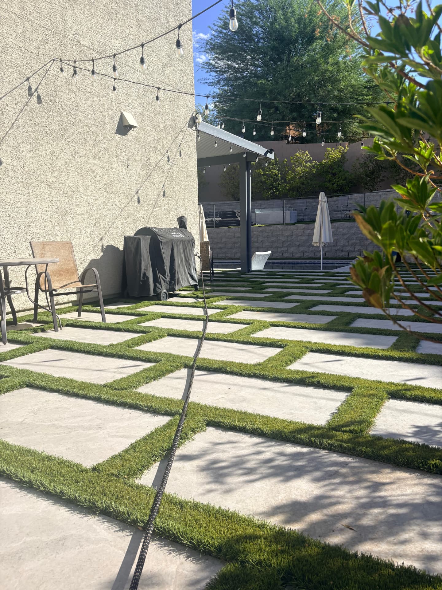 Artificial turf and concrete paver backyard installation